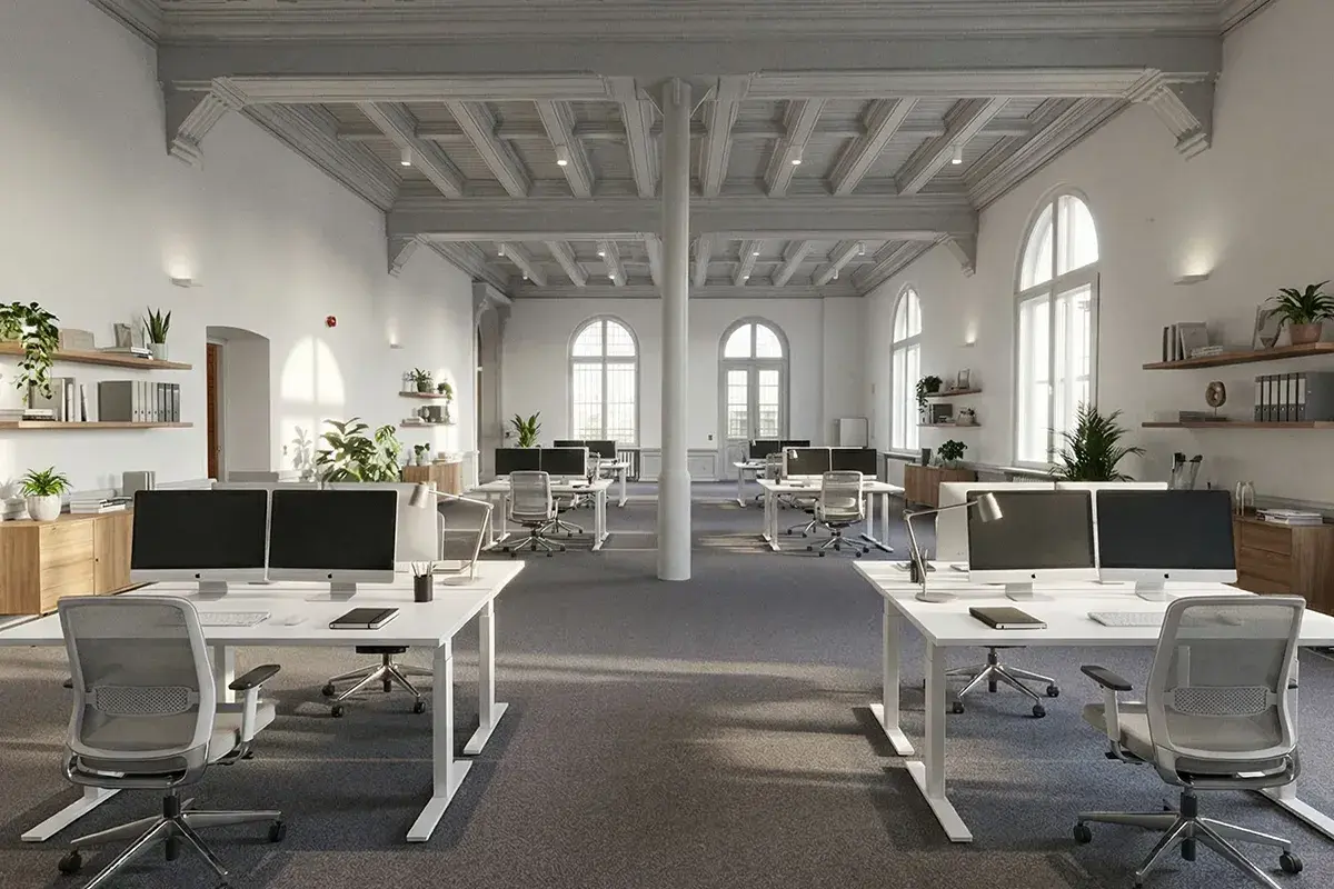 Virtual staging of an open plan office with white desks and plants in a historic hall with arched windows, made from a photo of the empty room with RenderAI